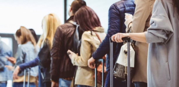 Passengers standing in line with luggage