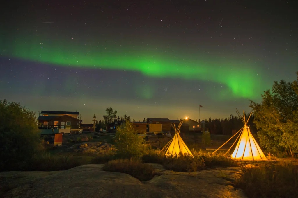 Two tipis in Yellowknife, with the aurora overhead