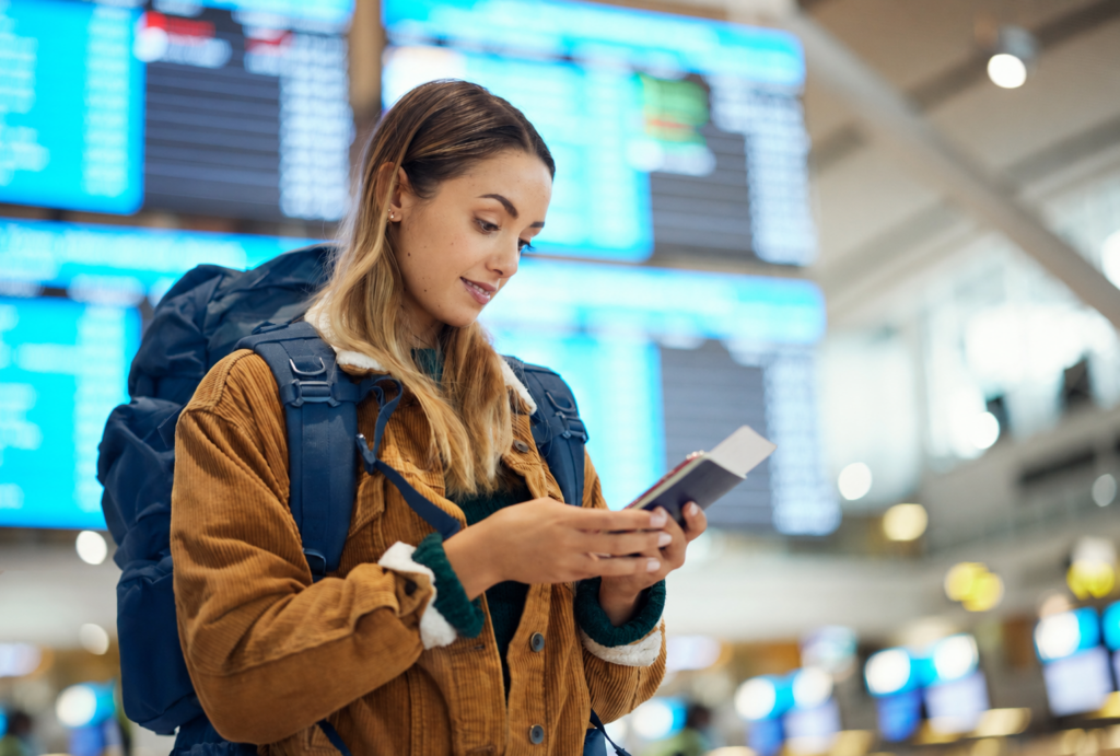 female student at airport looking up flight information